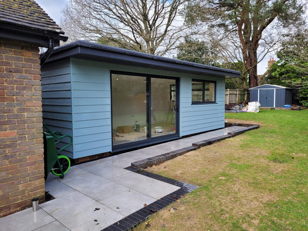 Modern outdoor garden room by Deerwood Construction in Crowborough East Sussex featuring cladding and sliding doors.